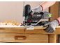 Person benutzt eine Stichsäge, um Holz auf einer Werkbank zu schneiden.