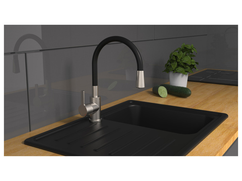 Eine schwarze Spüle mit einem verchromten Wasserhahn