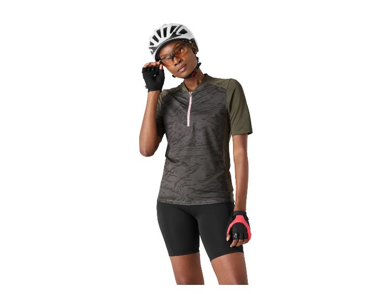 Frau in Radtrikot, Shorts, Helm und Radhandschuhen.