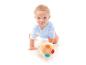 Lächelndes Baby im blauen Body spielt mit einem bunten Ball auf weißem Hintergrund.