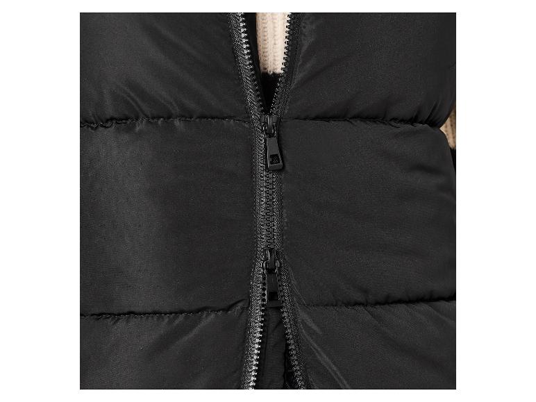 Nahaufnahme einer schwarzen Steppweste mit teilweise geöffnetem Reißverschluss, der einen cremefarbenen Strickpullover zeigt.
