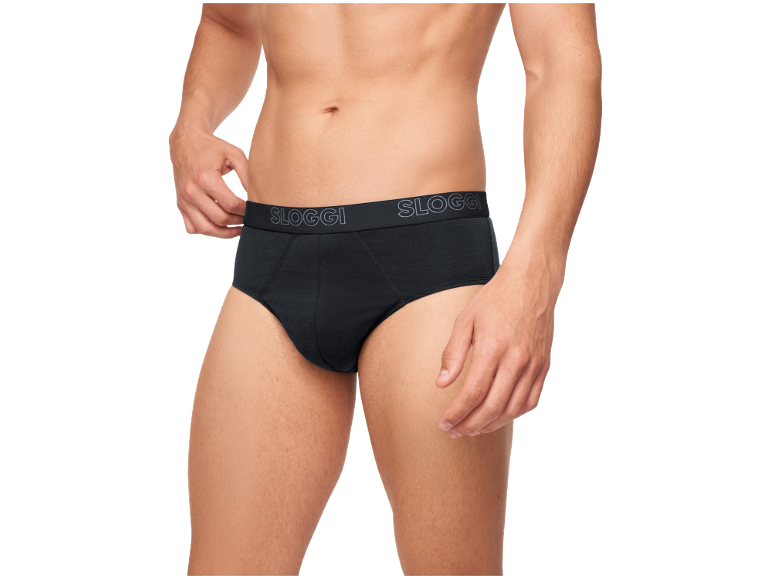 Mann in schwarzen Slips, passt den Bund mit der Hand an.