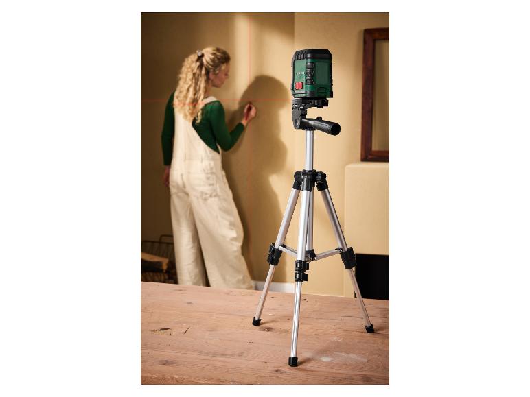 Frau markiert Wand mit Parkside Laserwasserwaage auf Stativ.
