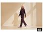 Frau in ESMARA® Premium Sweathose und passendem Hoodie geht in hellem Raum. [KI-generiertes Bild]