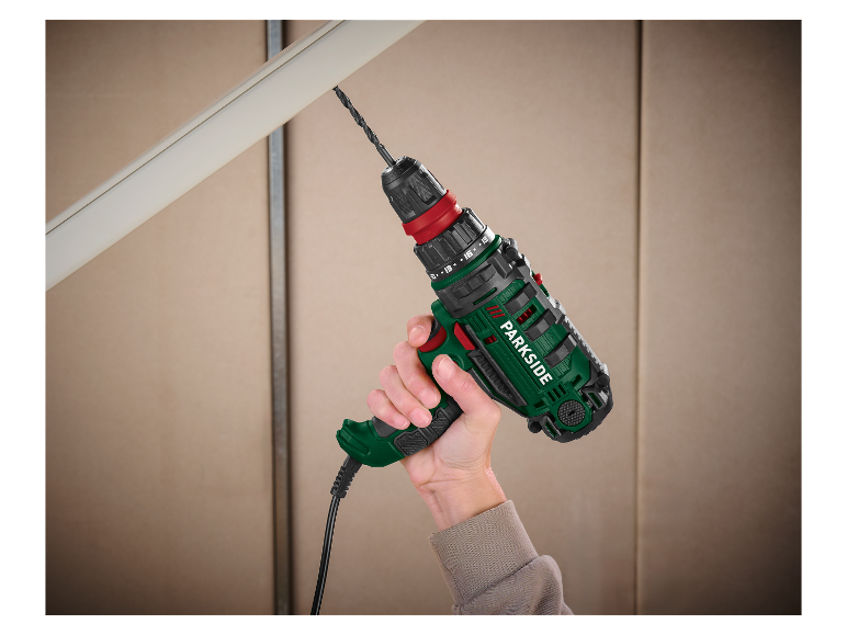 Hand mit Parkside Bohrmaschine, die in Plastik bohrt.