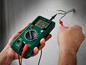 Eine Person testet die Spannung eines Kabels mit einem Parkside Multimeter.