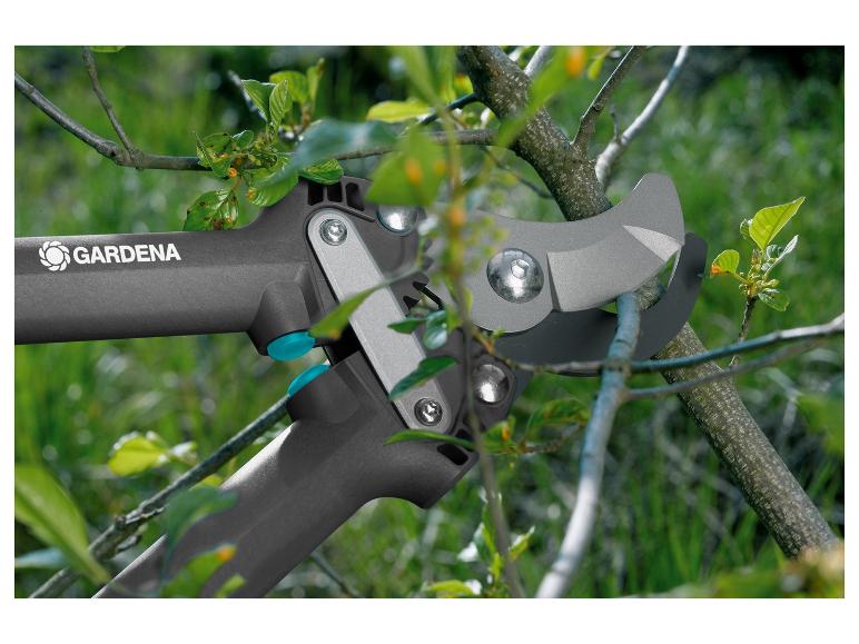 GARDENA Astschere schneidet einen Ast mit grünen Blättern.
