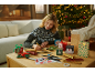 Frau bastelt Weihnachtsgeschenkboxen und -tüten mit festlichen Designs.