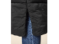 Detail einer schwarzen Steppjacke mit seitlichem Reißverschluss, über blauen Jeans getragen.