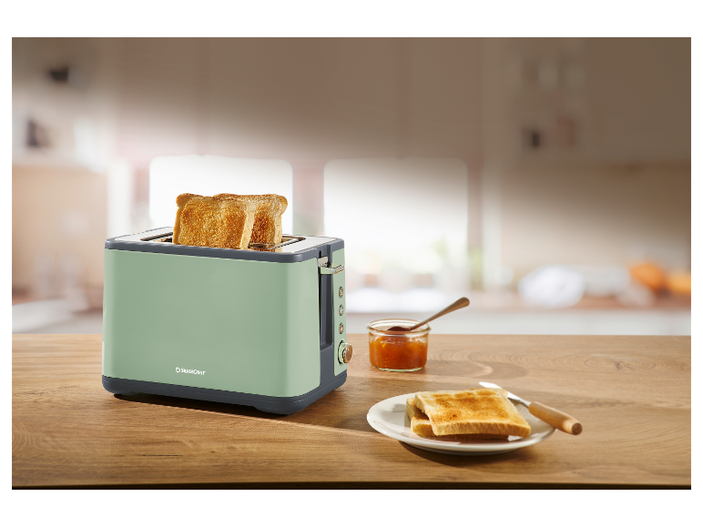 Ein mintgrüner SilverCrest Toaster mit geröstetem Brot und Marmelade.