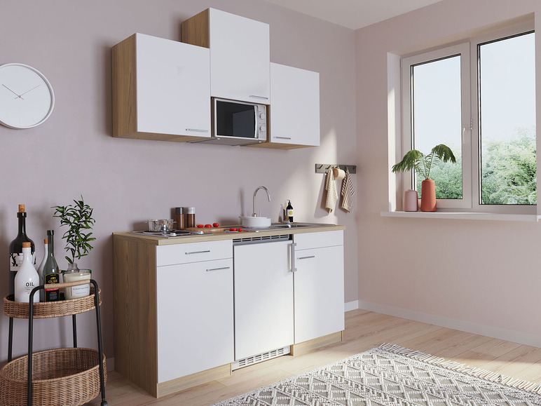 Eine kleine Küche mit weißen Schränken, einem Backofen und einem Geschirrspüler.