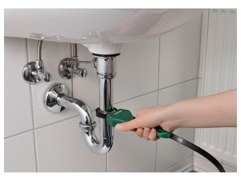 Hand benutzt ein Parkside Abflussreinigungsgerät an einem Spülrohr.