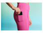 Eine Frau trägt rosafarbene Leggings mit einem Handy in der Tasche.