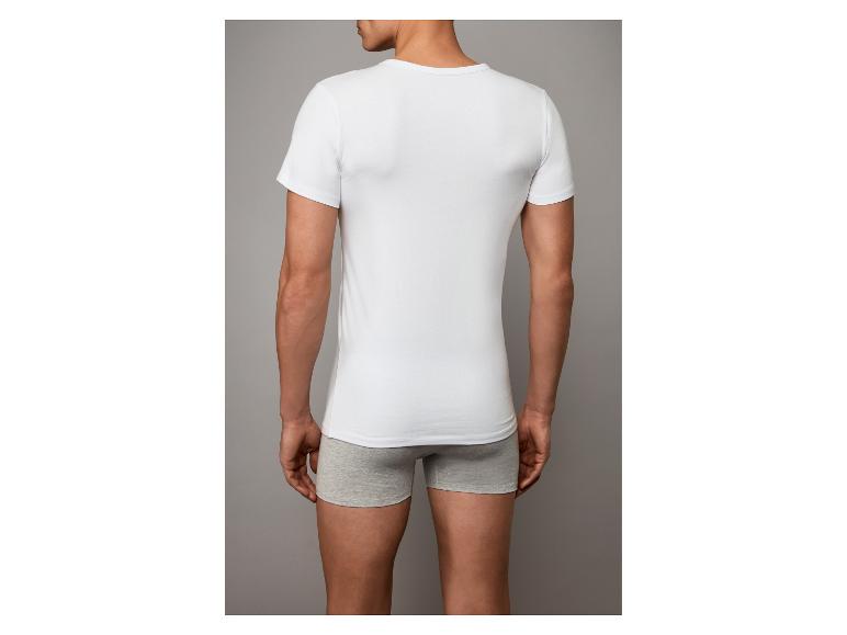 Rückenansicht eines Mannes in weißem T-Shirt und grauen Boxershorts.