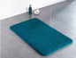 Eine türkisfarbene Badezimmermatte auf dem Boden.