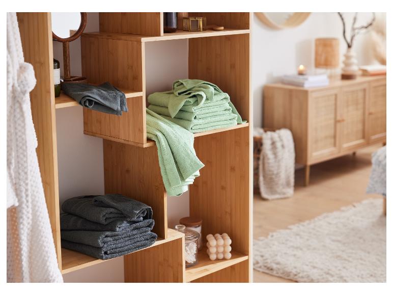 Ein Holzregal im Badezimmer mit Handtüchern, Spiegel und Badprodukten.