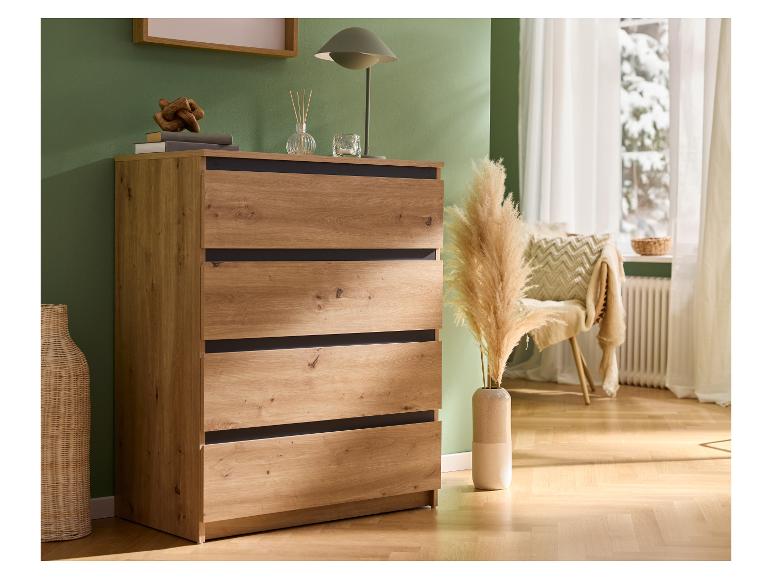 Holzkommode mit Schubladen, Dekorationen und Pampasgras in einem Raum mit grüner Wand.