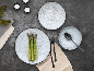 Set aus Keramiktellern und -schalen mit Besteck und Spargel