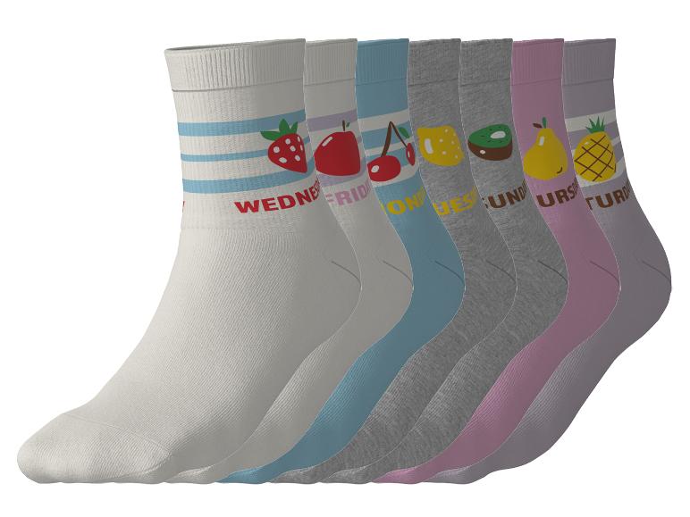 Sieben bunte Socken mit Früchten und Wochentagen, diagonal angeordnet.