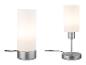 Zwei moderne Tischlampen mit zylindrischen Milchglasschirmen und Metallsockeln.
