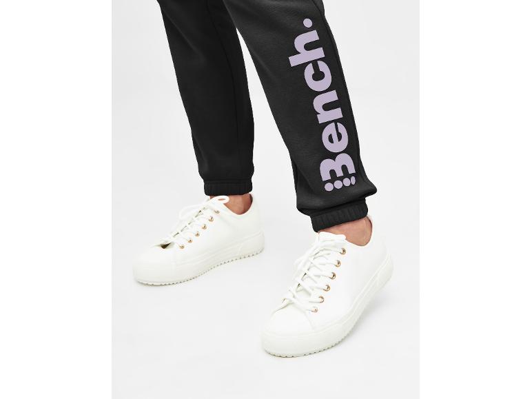 Schwarze Jogginghose mit Bench-Logo und weiße Sneaker.