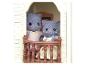 Zwei Sylvanian Families Katzen in einer Balkonöffnung.