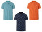 Drei Poloshirts mit kurzen Ärmeln: ein hellblaues, ein orangenes und eines mit Ananas-Muster.