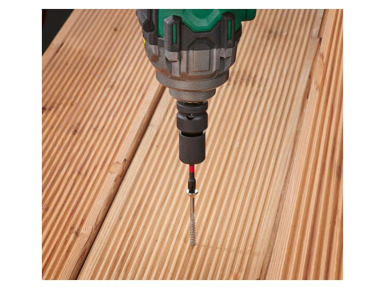 Bohrmaschine schraubt eine Schraube in ein Holzbrett.