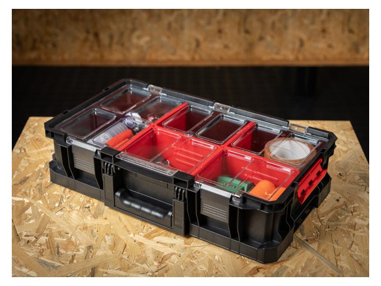 Schwarze Organizer-Box mit transparentem Deckel und roten Fächern, gefüllt mit verschiedenen Kleinteilen.