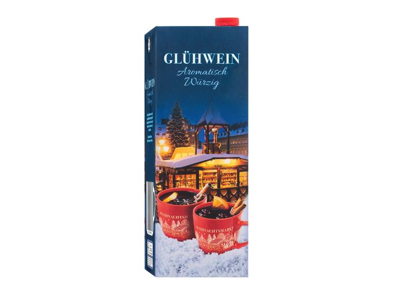 Glühwein-Karton mit Weihnachtsmarkt-Motiv und zwei roten Tassen im Schnee.
