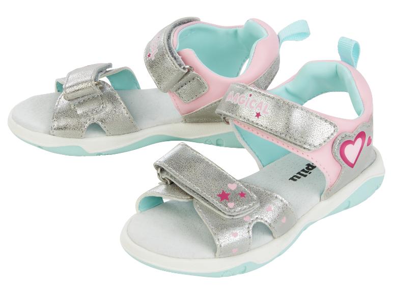 Zwei Paar rosa und silberne Sandalen mit magischem Thema