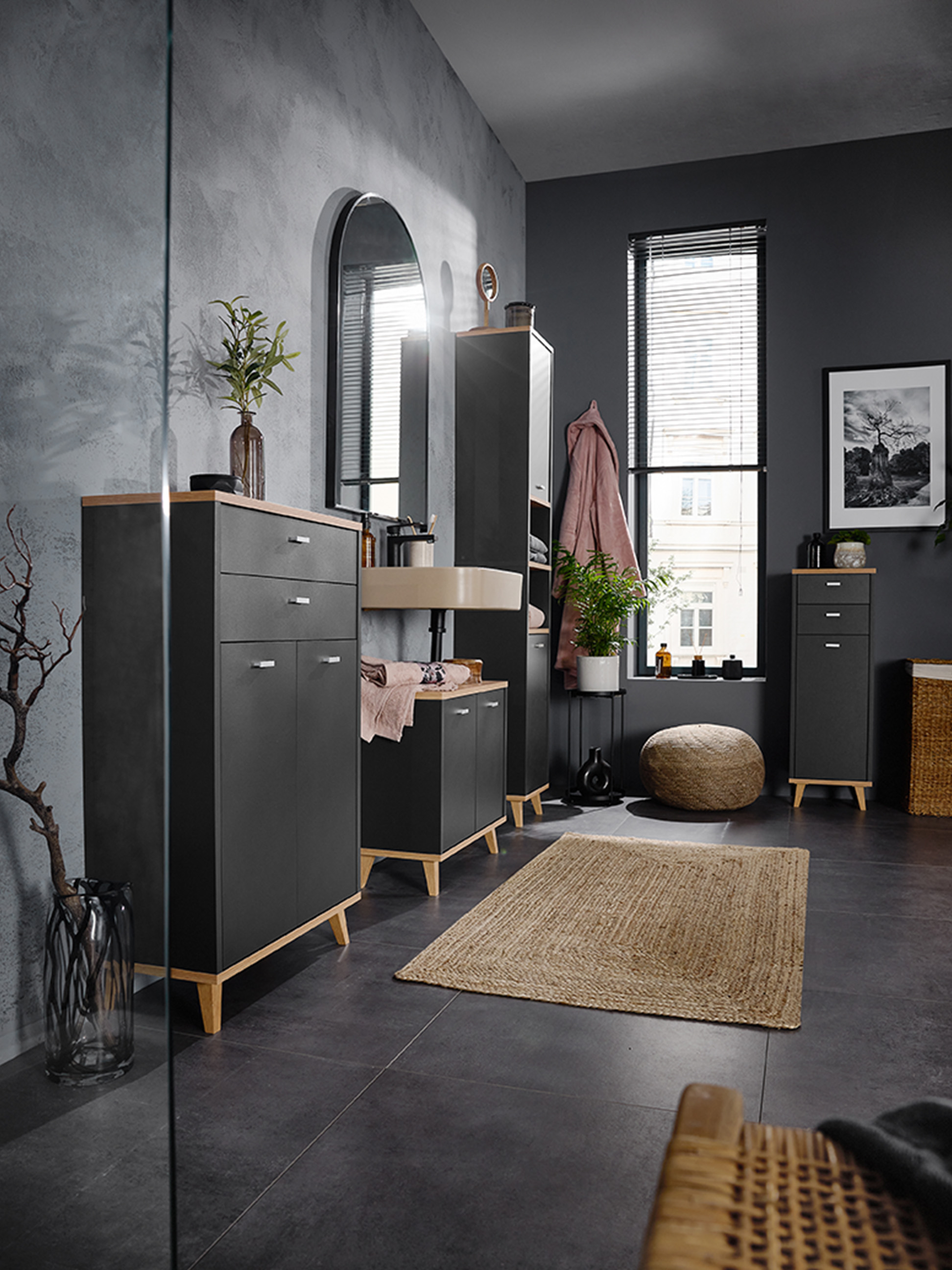 Badezimmer mit dunkelgrauen Schränken, Holzdetails und einem wandmontierten Waschbecken.