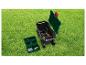 Gartenwagen mit Werkzeugen und Aufbewahrungsbox auf grünem Rasen.