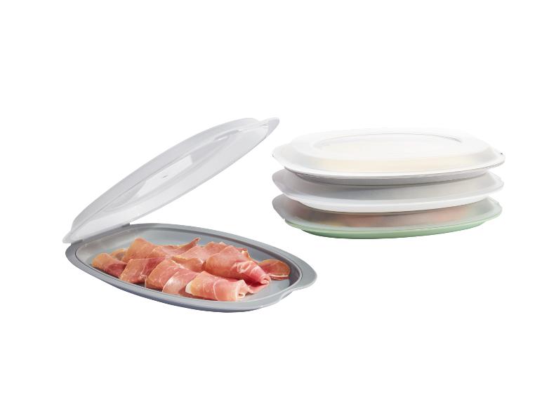 Stapelbare Tabletts mit Deckeln, eines mit Serrano-Schinken.