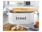 Eine weiße Brotdose mit Holzdeckel und Brot daneben