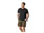 Mann in schwarzem T-Shirt und Khaki-Shorts, hält eine Wasserflasche.