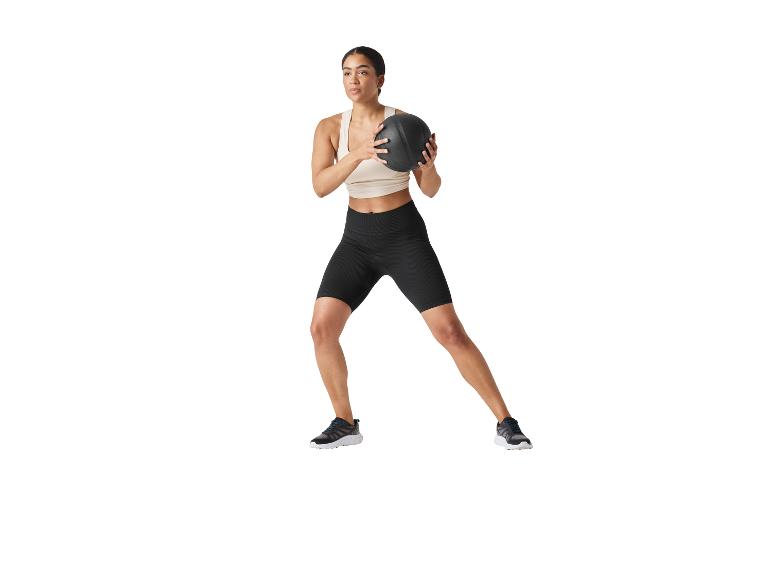 Frau trainiert mit einem Medizinball.