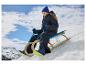Ein Kind beim Schlittenfahren im Schnee mit CRIVIT Skihandschuhen und Winterkleidung.