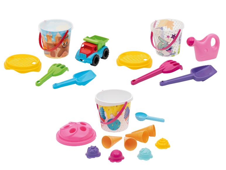 Drei Sandspielzeug-Sets mit Eimern, Schaufeln, Rechen und Förmchen.