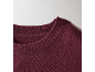 Detail des gerippten Rundhalsausschnitts eines bordeauxroten Strickpullovers.