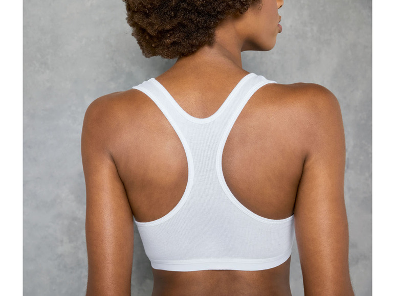 Eine Frau trägt einen weißen Sport-BH.