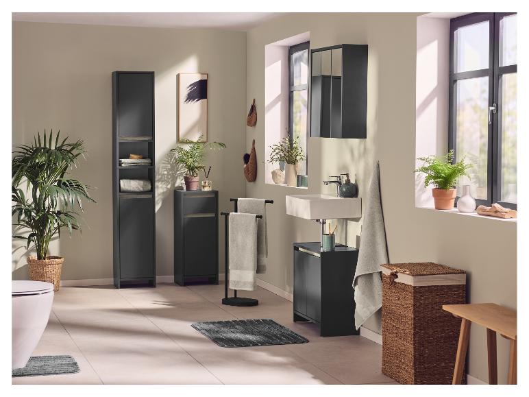 Badezimmer mit schwarzen Schränken, Waschbecken, Toilette, Pflanzen und Textilien.