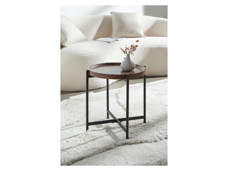 Runder Beistelltisch aus dunklem Holz mit schwarzem Gestell auf weißem Teppich.