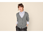 Frau in grauem Cardigan, hellblauem Hemd und schwarzer Lederhose