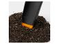 Schwarze Gartenkelle mit oranger Spitze in Erde