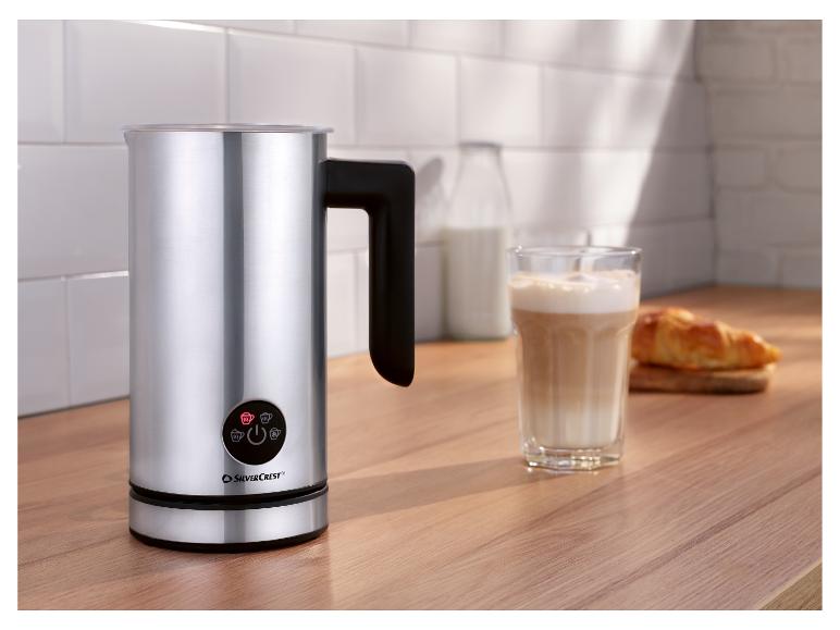 SilverCrest Milchaufschäumer auf einer Holztheke mit einem Glas Latte und einem Croissant.