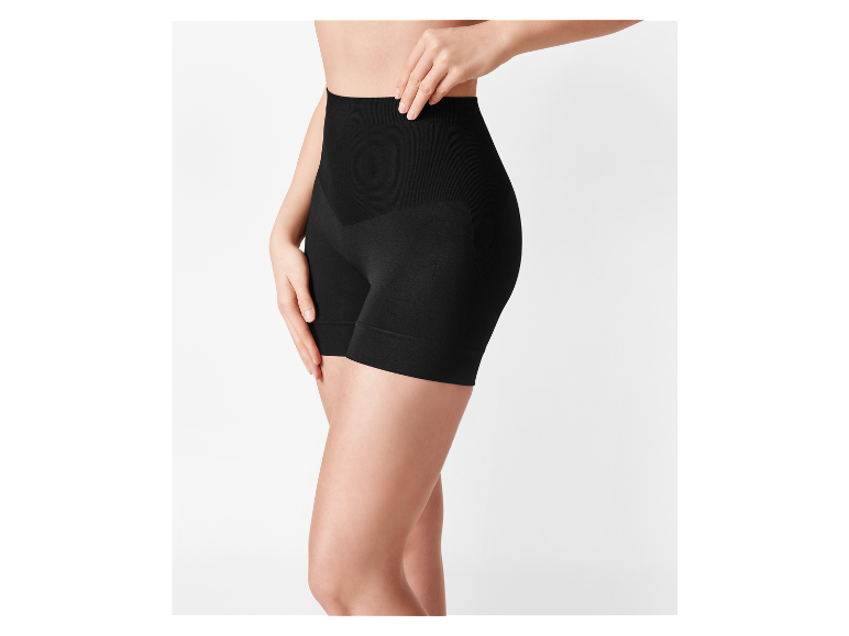Frau in schwarzen, hohen, formenden Shorts, mit der Hand an der Hüfte.