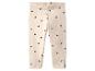 Beige Kinderleggings mit schwarzen Herzen.