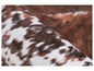 Nahaufnahme eines weißen und braunen Teppichs mit Kuhmuster.