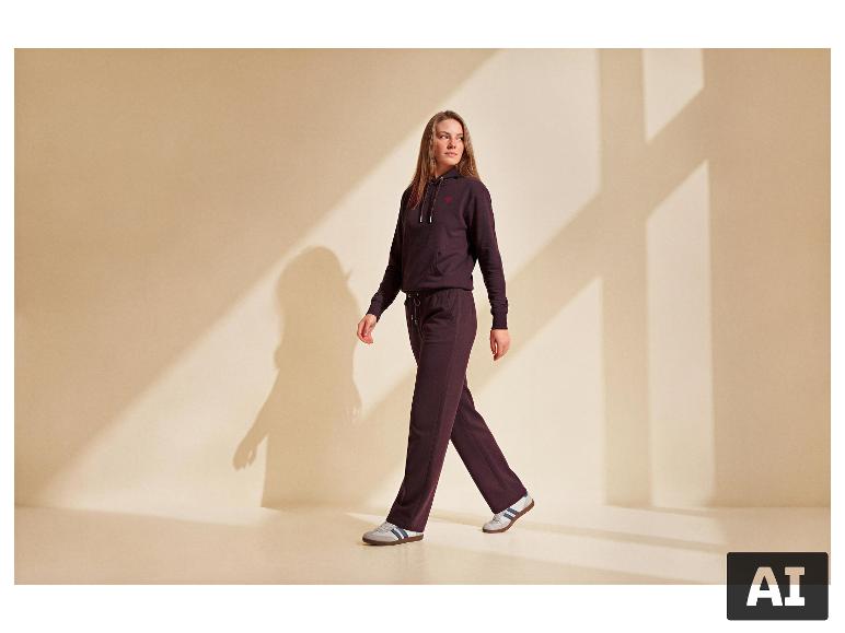 Frau in ESMARA® Premium-Sweatpullover und passender Hose geht nach rechts. [KI-generiertes Bild]